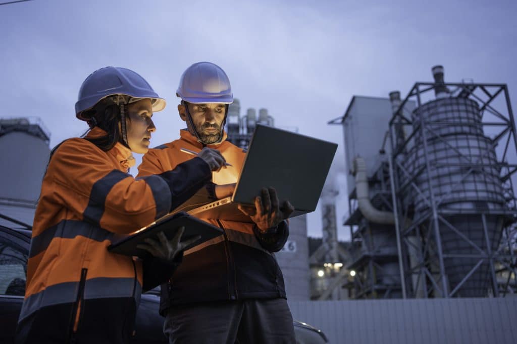 Des ingénieurs étude calcul travaillant en extérieur devant une centrale nucléaire